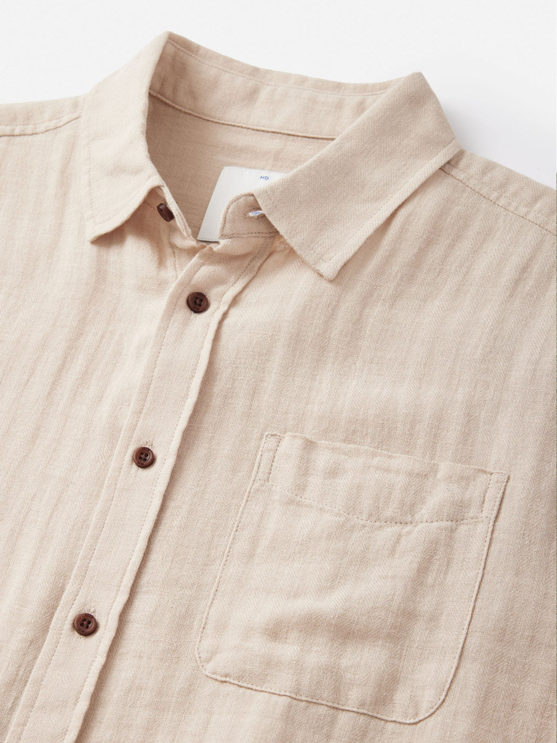 The Katin Alan Solid Shirt by Katin is a beige, long-sleeve button-up with a classic collar, single chest pocket, and brown buttons, made from quality materials and shown laid flat on a white background.