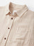 The Katin Alan Solid Shirt by Katin is a beige, long-sleeve button-up with a classic collar, single chest pocket, and brown buttons, made from quality materials and shown laid flat on a white background.