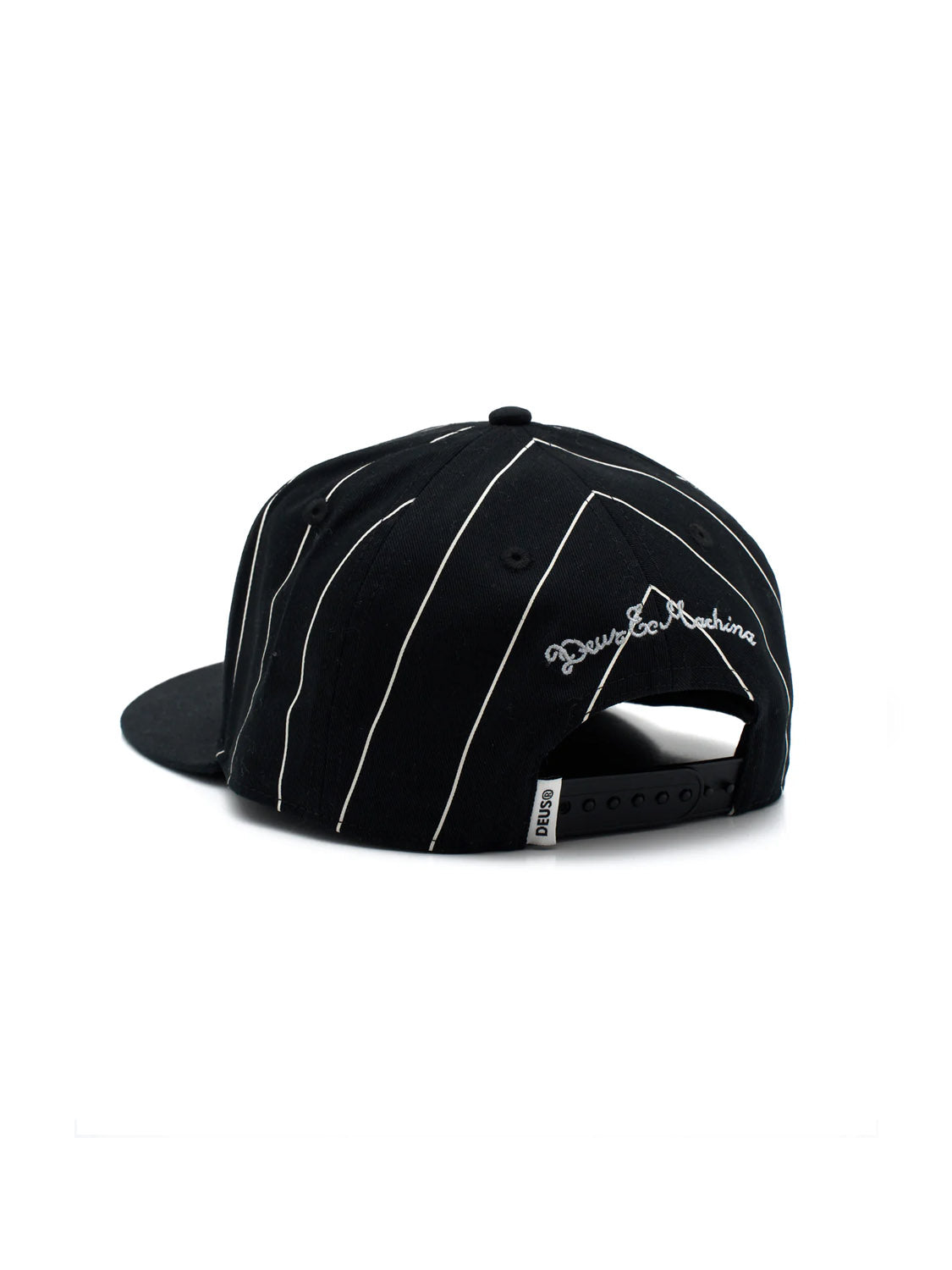 The Alvia Cap by Deus is a black cotton twill snapback with white pinstripes, "Deus" embroidered above the closure, and a small white tag near the strap, giving a vintage baseball hat feel when viewed from the back.