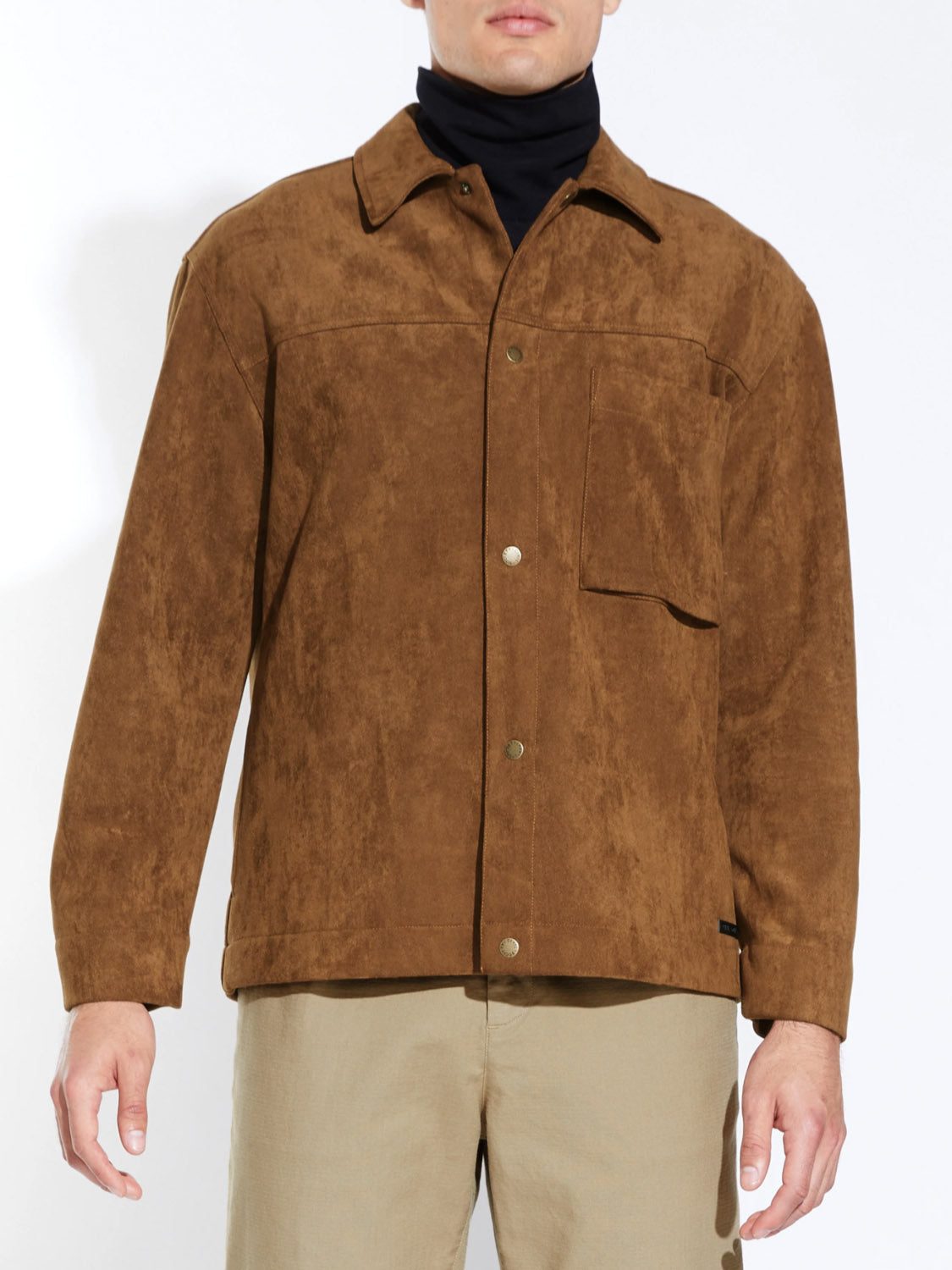 A person wears the Civil Society Ansel Boxy Fit Suede Shirt Jacket in brown with snap buttons and a 3D chest pocket, paired with beige pants. Only the torso and upper legs appear against a plain white background.