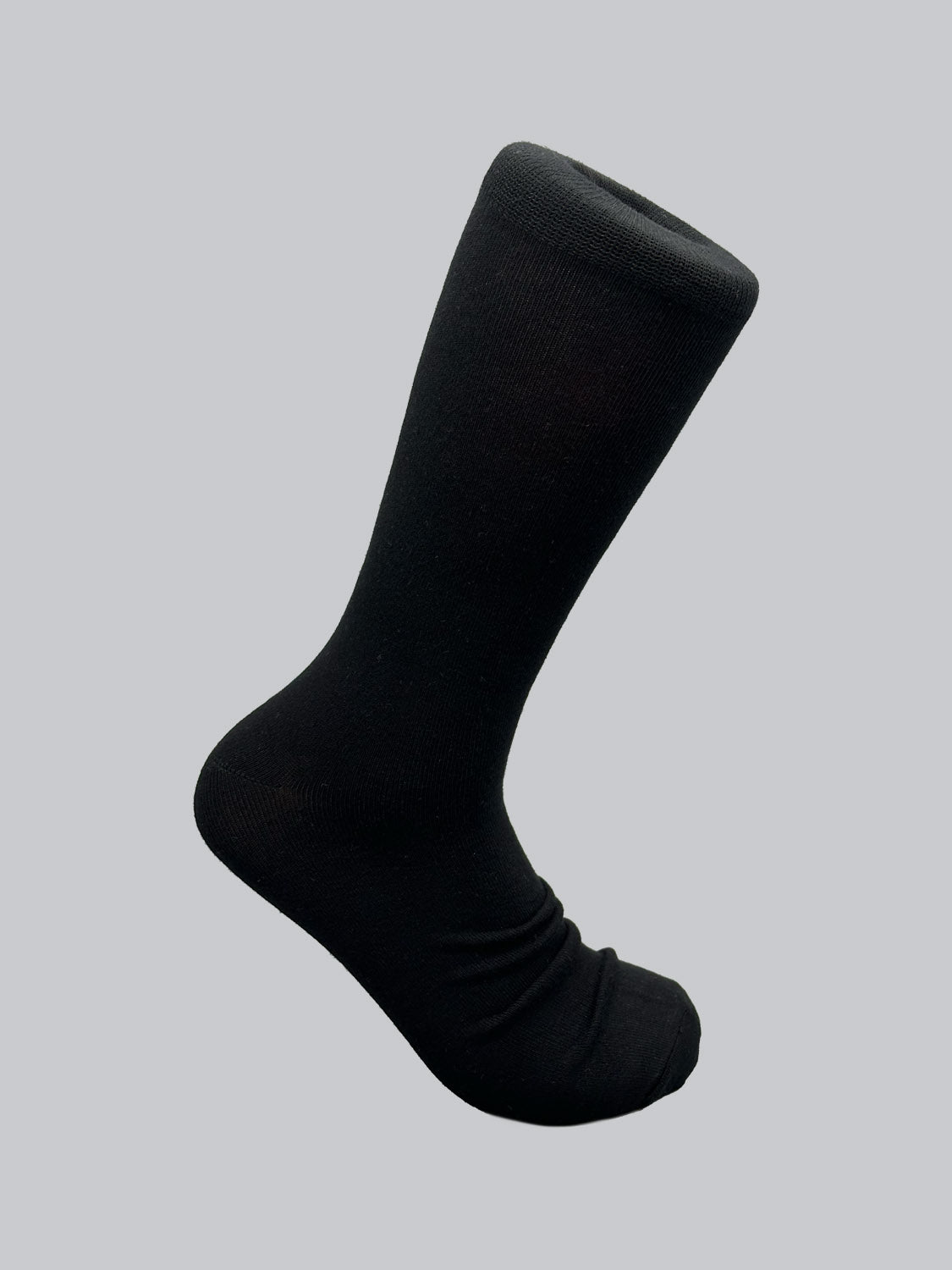 A single Cylinder Knit Bamboo Solid Sock by ID Menswear stands upright against a light grey backdrop, showcasing its length and toe area. Crafted from eco-friendly bamboo, it highlights the sustainable nature of these socks.