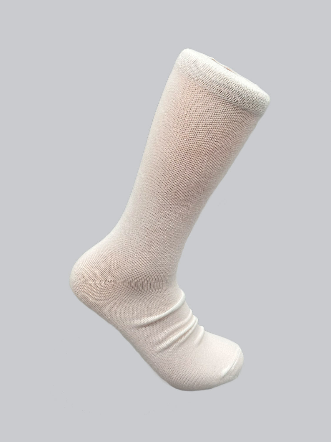 A single white Cylinder Knit Bamboo Solid Sock from ID Menswear, made from eco-friendly bamboo, is shown against a gray background. It has a smooth texture and appears to be mid-calf length.