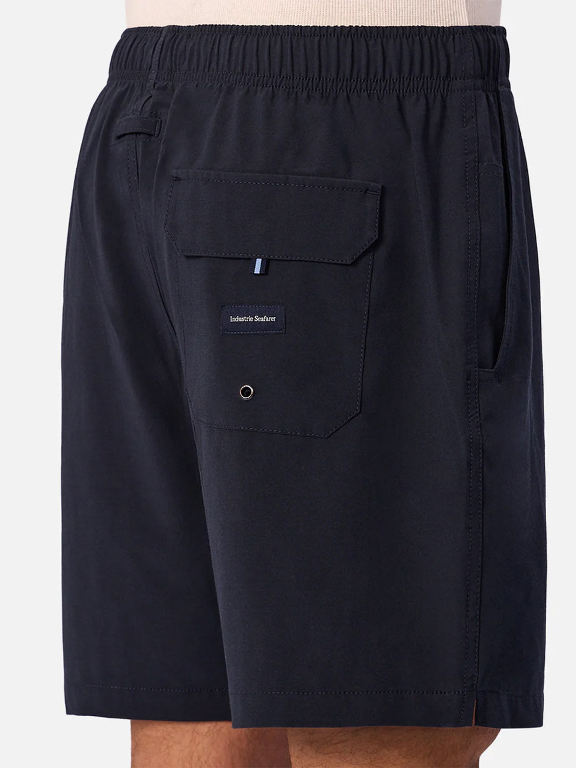 A close-up side view of a person in Industrie’s The Barbados Swim Shorts—men's quick-dry, dark navy swim trunks with an elastic waistband, flap back pocket, small label, and eyelet—ideal for pool or beach days.