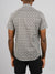 A person faces away from the camera, wearing the Bellis Printed Cotton Shirt by ID Menswear, which features a black and white circular pattern, paired with black shorts against a plain light gray background.