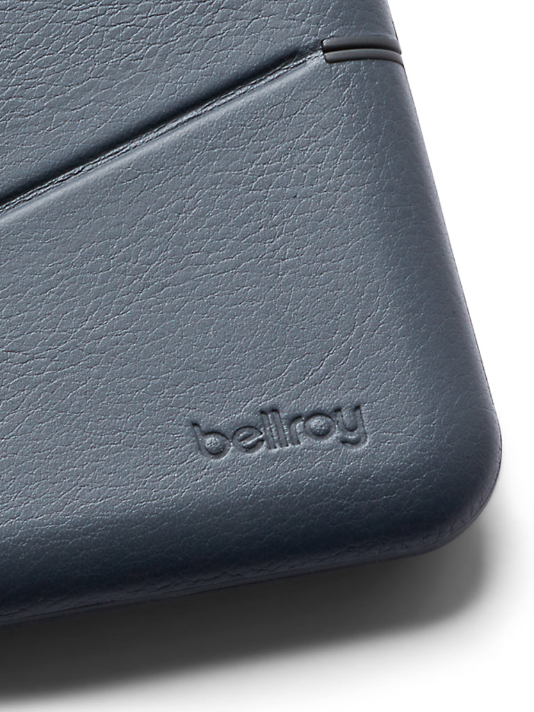 Close-up of the Bellroy Flip Case Wallet in dark gray eco-tanned leather, showing rounded edges, subtle stitching, embossed logo, and built-in RFID protection.