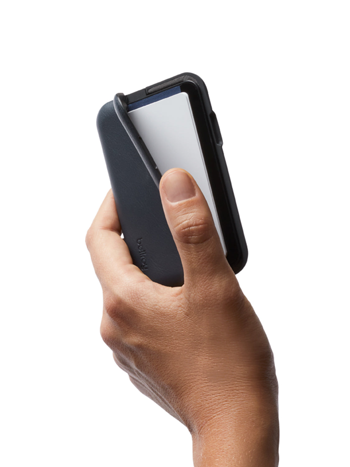 A hand holds the Bellroy Flip Case Wallet, a slim black RFID-protected double-sided wallet, with a white card partially slid out, against a plain white background.
