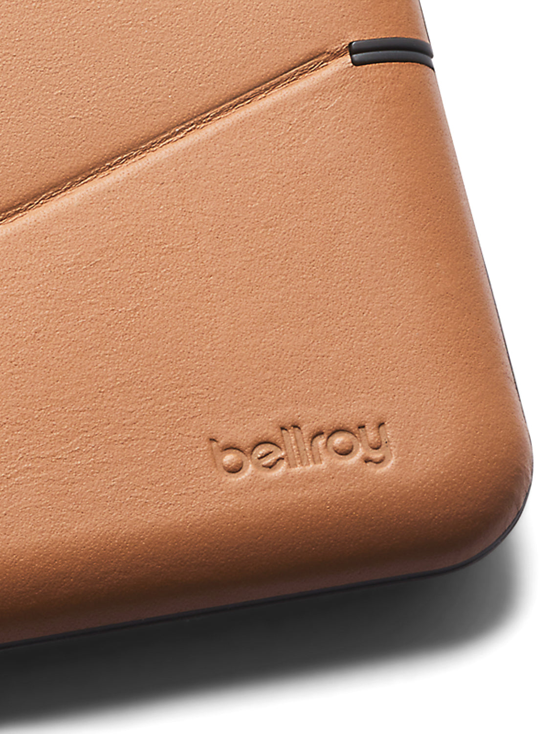 Close-up of a tan eco-tanned leather Flip Case Wallet by Bellroy, showing visible stitching and the brand name embossed on the surface.