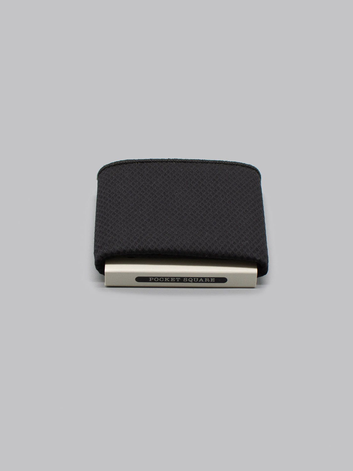 The Berlin Pocket Square by ID Menswear is a neatly folded black cotton pocket square with a silver holder labeled POCKET SQUARE, displayed on a plain gray background.