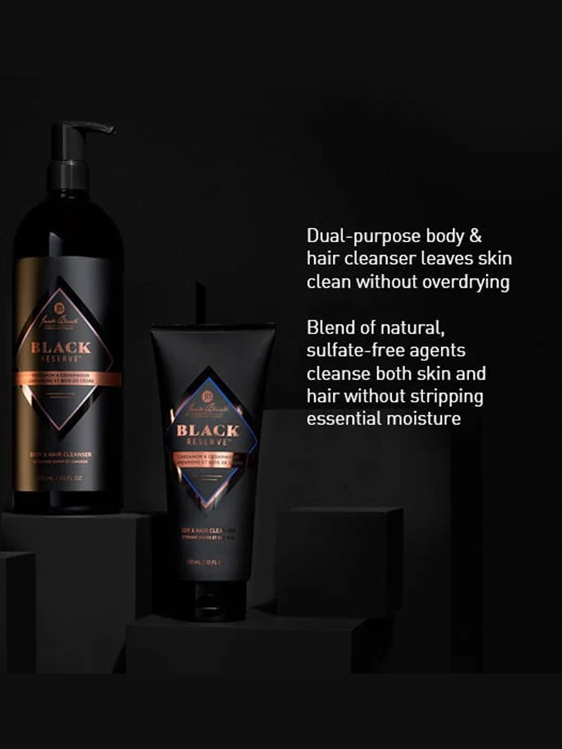 Two bottles of Jack Black Black Reserve™ Body & Hair Cleanser 10oz with gold accents sit on black blocks, highlighting the dual-purpose, sulfate-free formula that cleanses without overdrying.