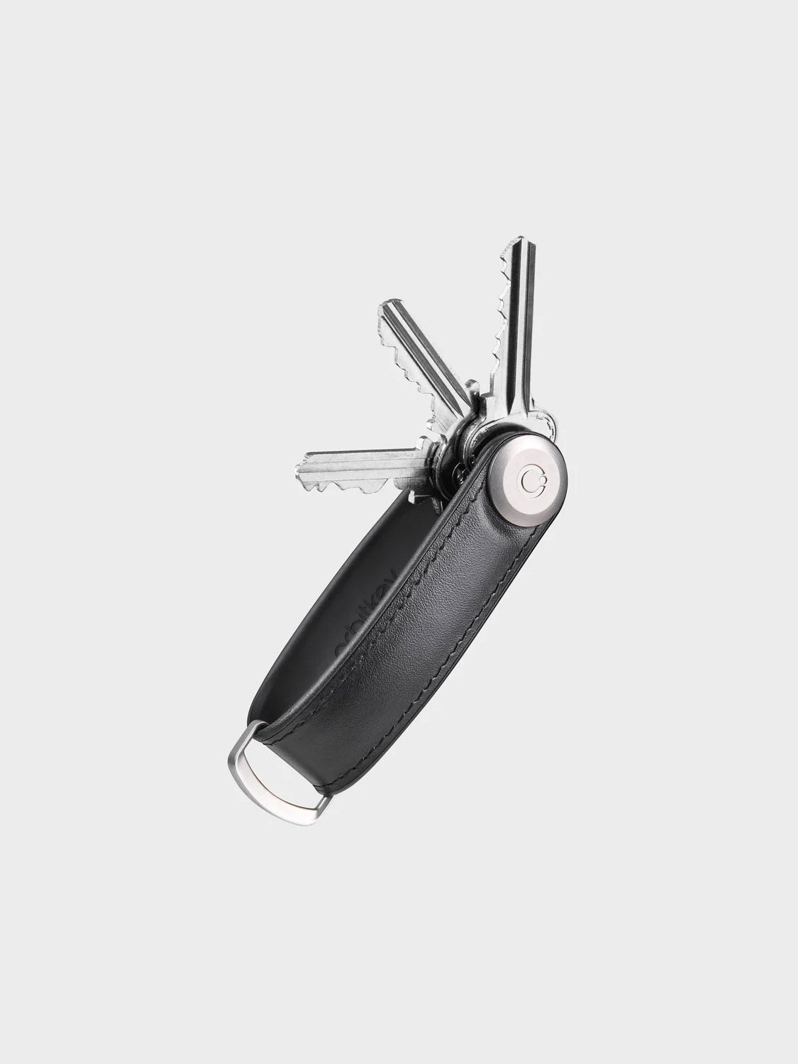 The Orbitkeys Key Organizer Hybrid Leather in black Nappa leather neatly stores several silver keys, fanned out from one end, against a plain light gray background, and features a secure locking mechanism for convenience.