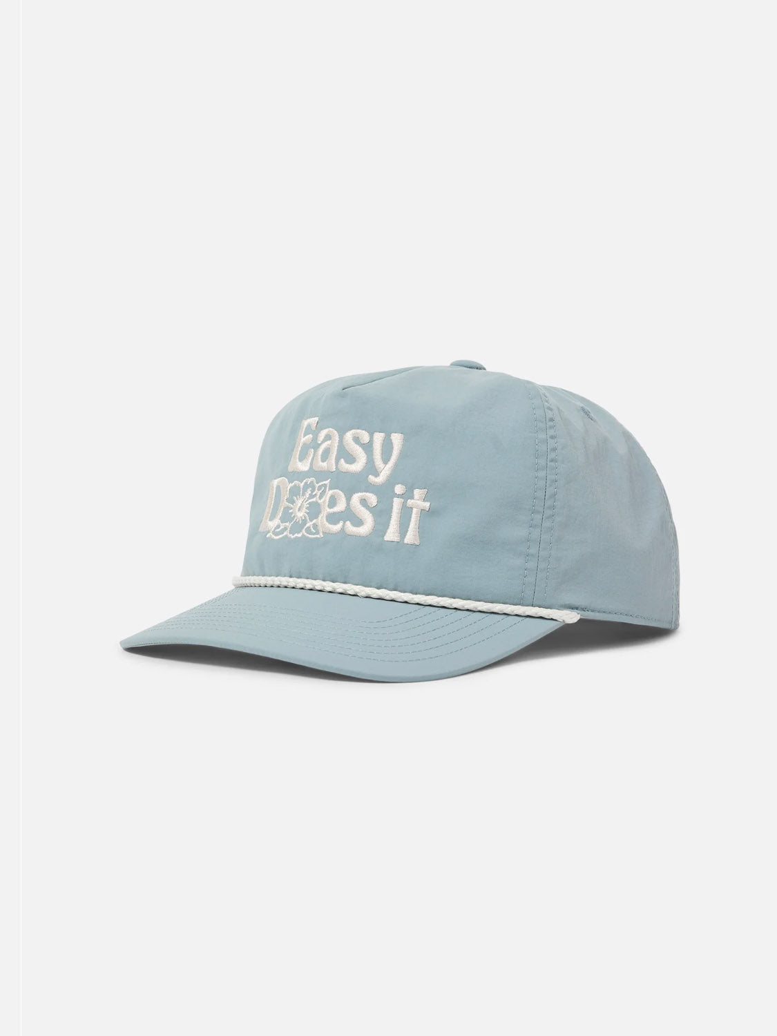 The Katin Bloom Hat is a light blue 5-panel cap featuring white "Easy Does It" embroidery with a small flower on the front, a white rope above the brim, and an adjustable snapback for comfort.