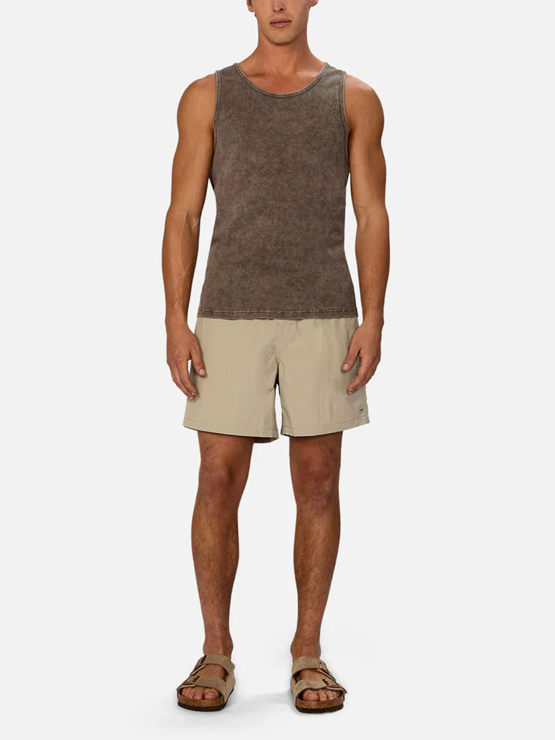 A man stands facing forward in the Industrie Washed Brando Ribbed Tank Top, paired with light beige shorts and tan sandals against a plain white background—an ideal look to refresh your summer wardrobe.