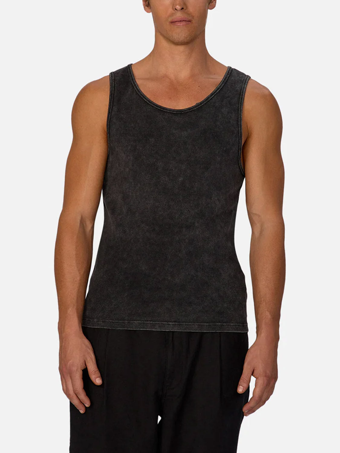 A man wears the Industrie Washed Brando Ribbed Tank Top and black shorts, facing forward against a plain light background—an ideal addition to your summer wardrobe.