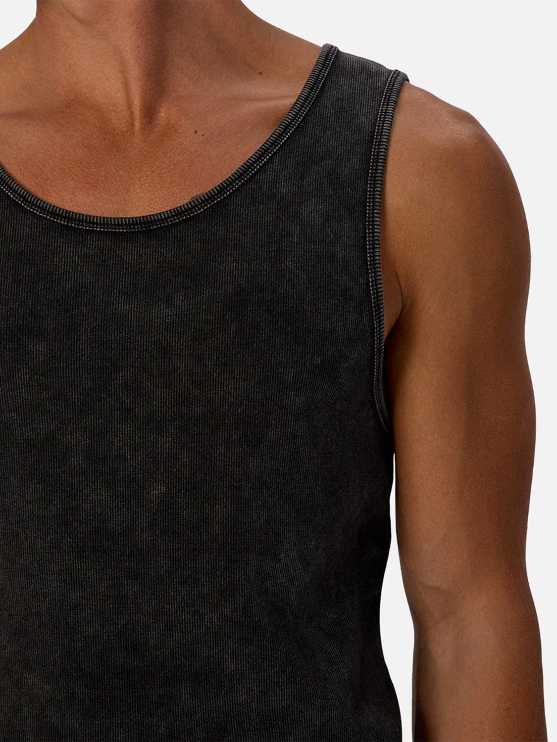 Close-up of a person wearing the Washed Brando Ribbed Tank Top by Industrie, showcasing their neck, shoulder, and upper chest against a plain light background.