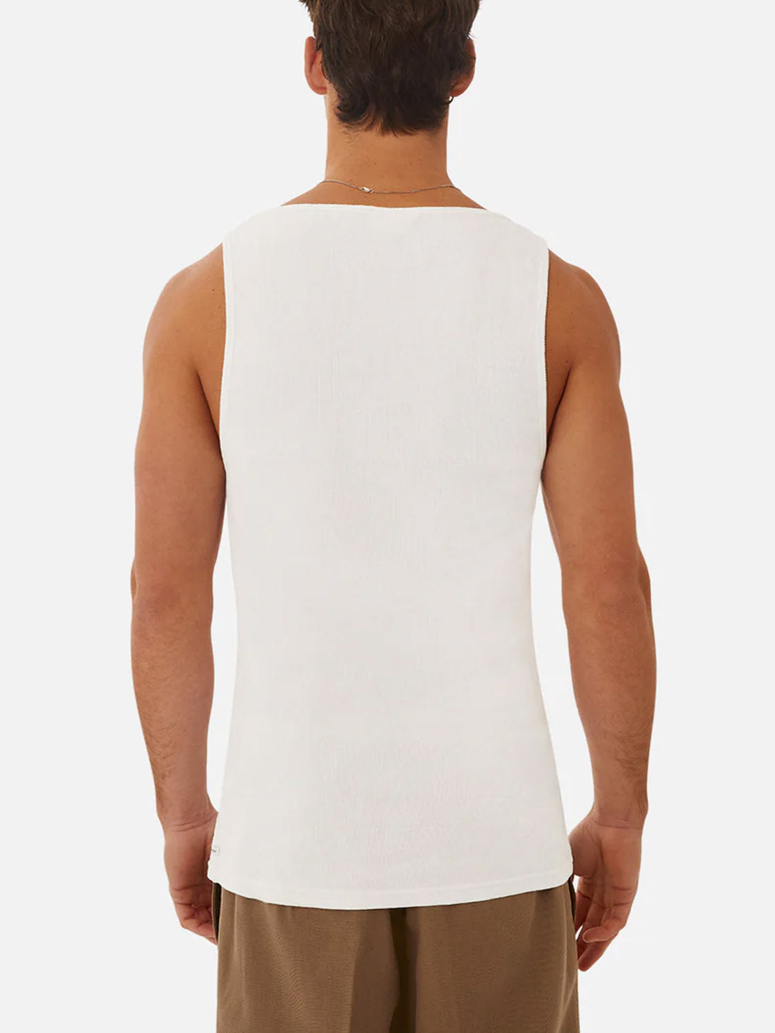 A man is seen from the back wearing the Industrie Washed Brando Ribbed Tank Top in white with brown shorts against a plain white background—ideal for refreshing your summer wardrobe.