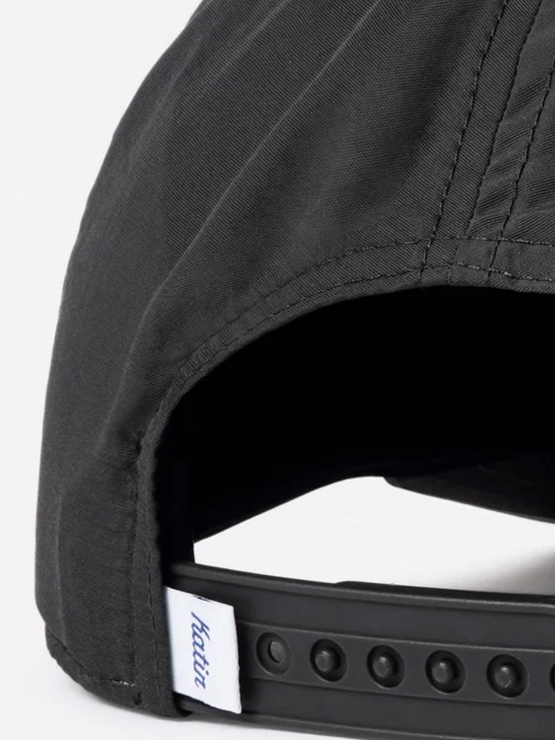 Close-up of the back of the Katin Breach Hat in black recycled nylon, showing its adjustable snapback closure and a white tag with blue "kaviar" text.