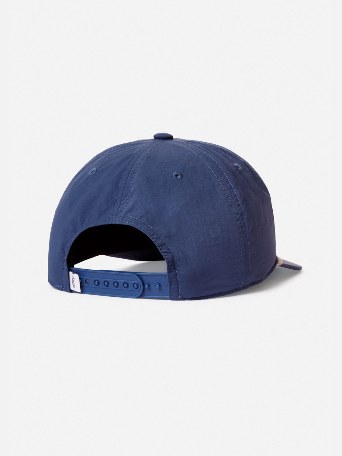 The Katin Breach Hat is a navy blue 5 panel cap shown from the back, featuring an adjustable snapback closure, a small white tag on the left side, and subtle Katin embroidery for a classic look.