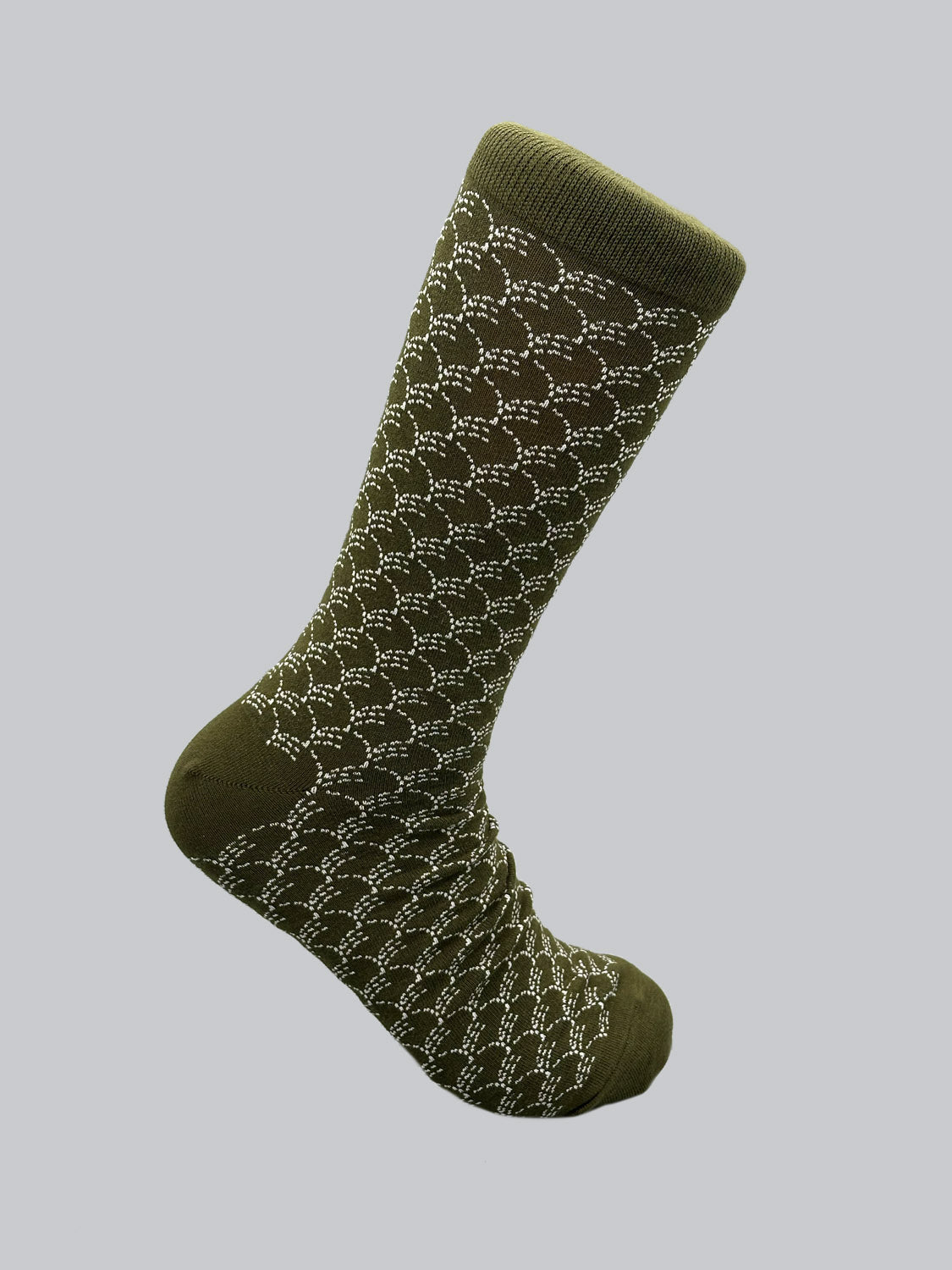 ID Menswears Broken Waves Graphic Socks are olive green with a white geometric pattern, crafted from combed cotton for premium comfort. The breathable and stretchy design is displayed against a light grey background, angled as if worn to emphasize the intricate texture.