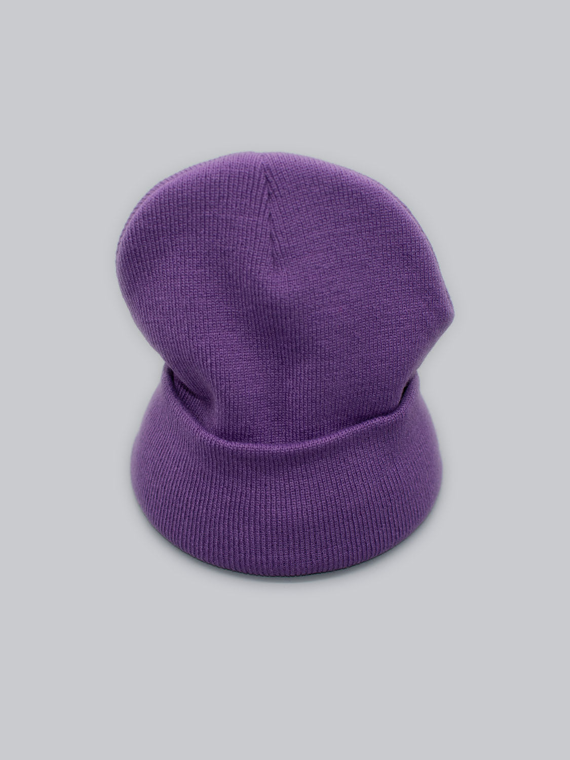 The Bronx Acrylic Beanie by ID Menswear is a chic purple knit cap, offering a stretchable fit with a folded brim and slouchy design. Presented on a light gray background, this acrylic beanie seamlessly blends comfort with style.