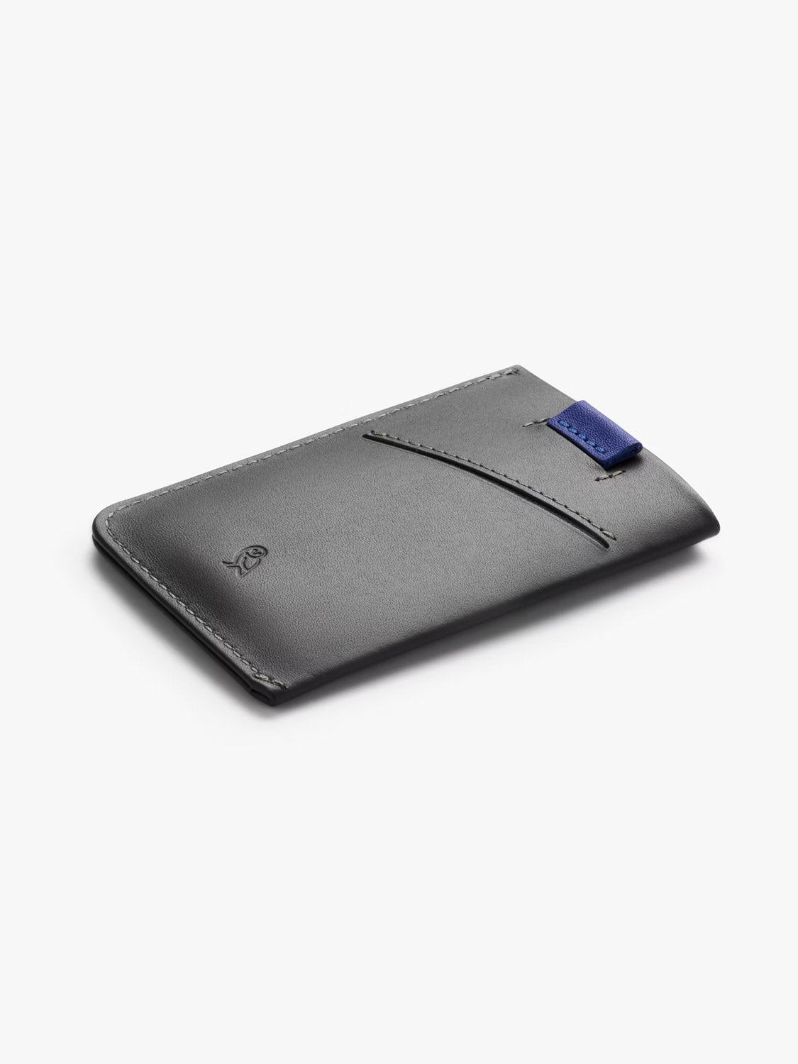 The Bellroy Card Sleeve Wallet is a slim, black minimalist wallet featuring a diagonal front pocket and a small blue fabric tab on the edge, shown against a white background.