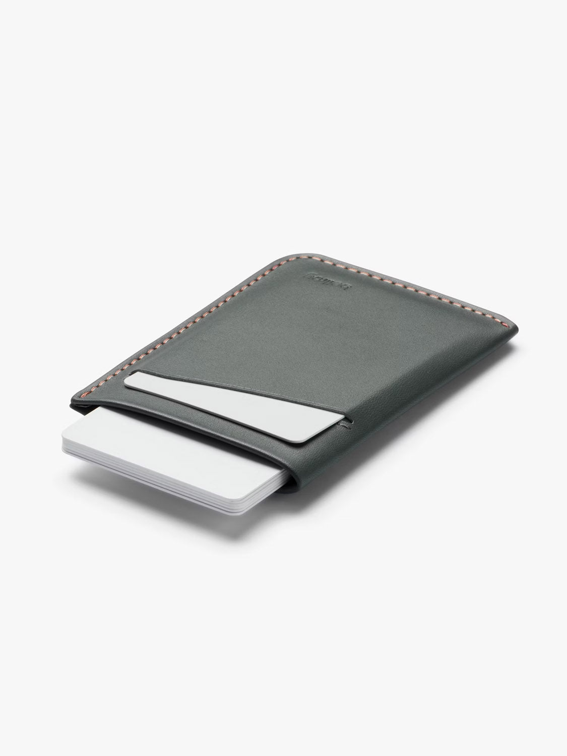 The Bellroy Card Sleeve Wallet, a slim dark gray minimalist accessory with light edge stitching, holds several white cards partially visible in two slots and is displayed on a plain white background.