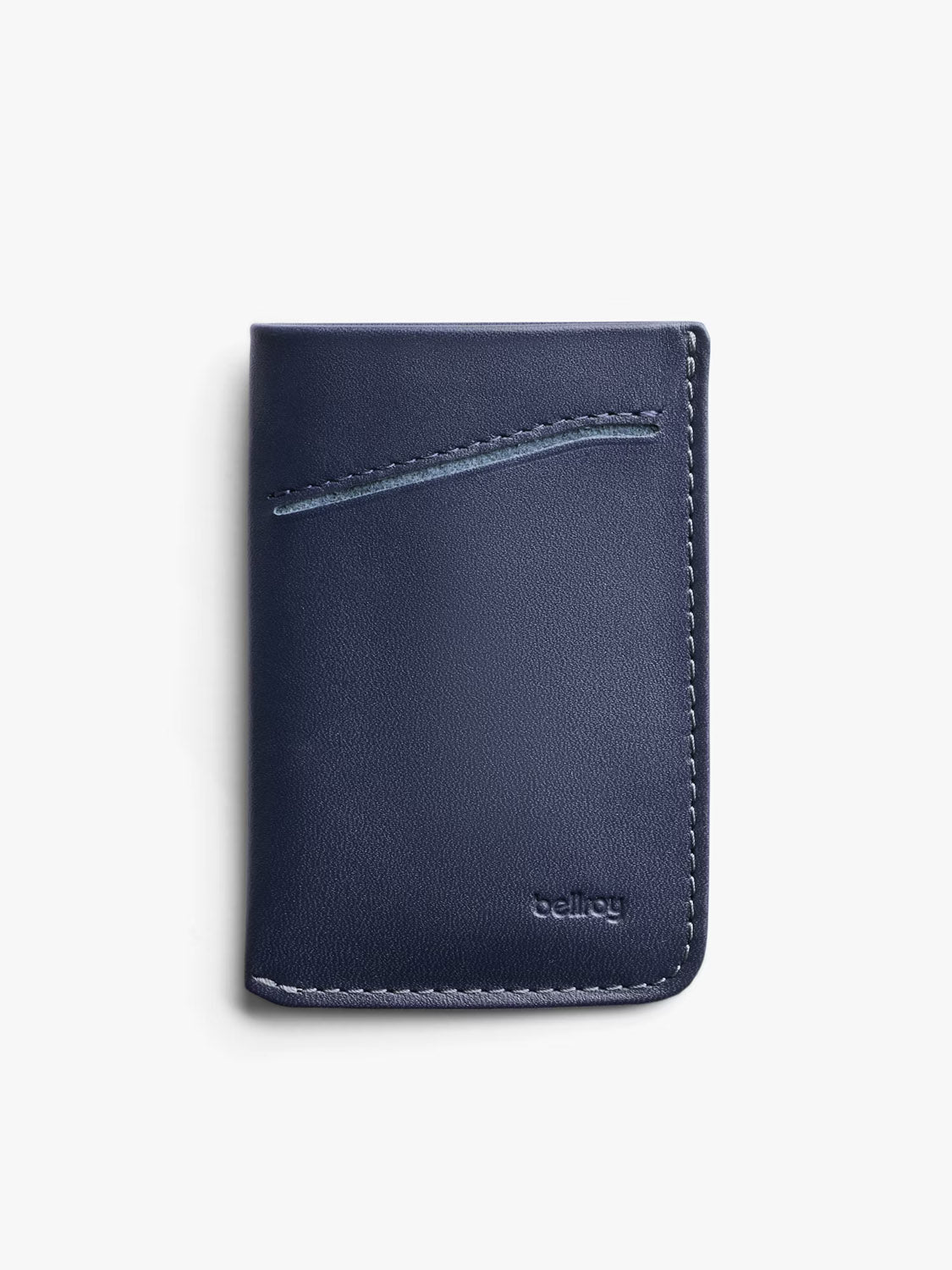 The Bellroy Card Sleeve Wallet is a navy blue premium leather card holder featuring a diagonal card slot and visible stitching along the right edge, displayed upright against a plain white background.