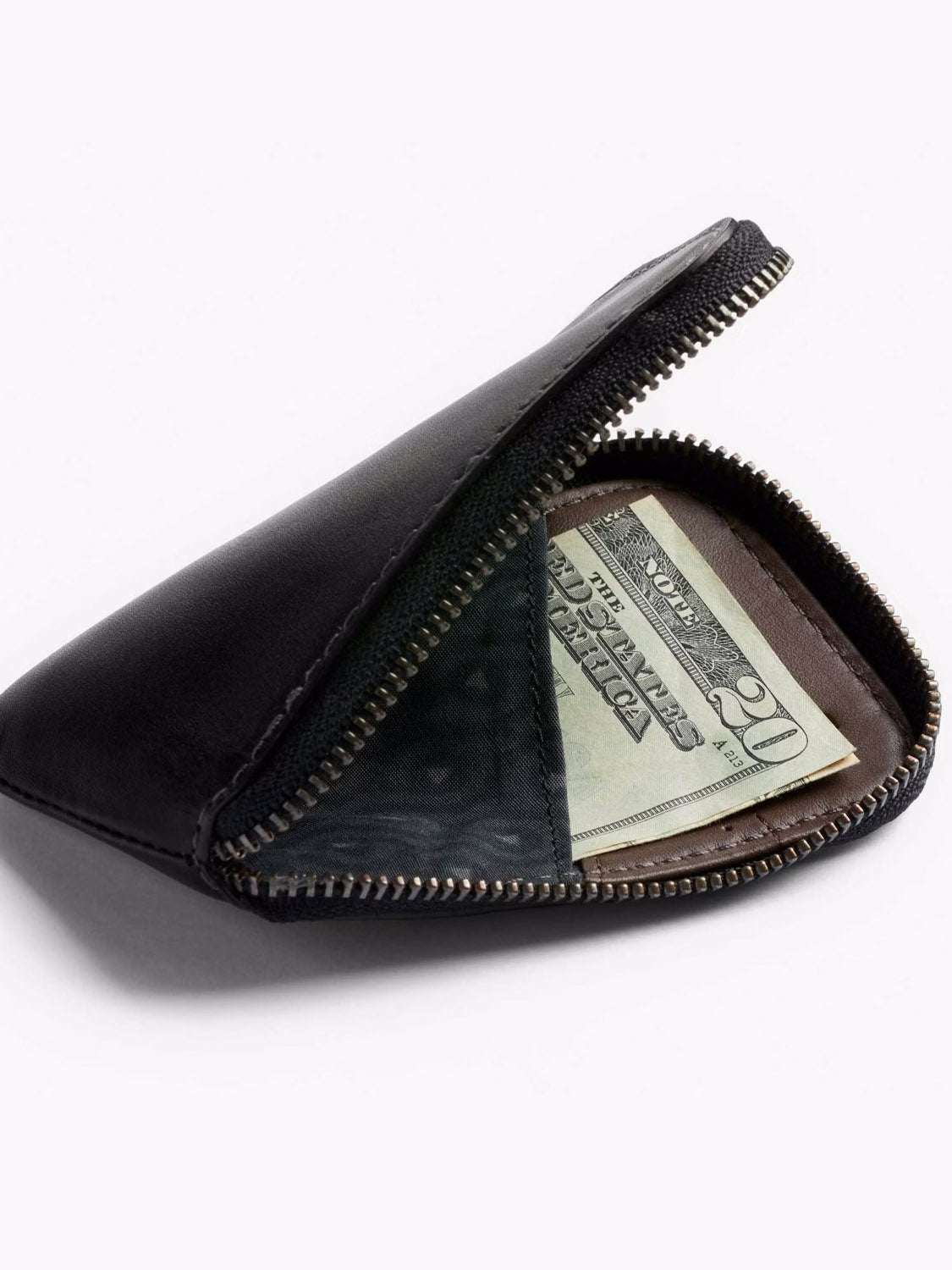 A Bellroy Card Pocket Wallet in black leather sits partially open on a plain white background, revealing neatly folded US twenty-dollar bills inside.
