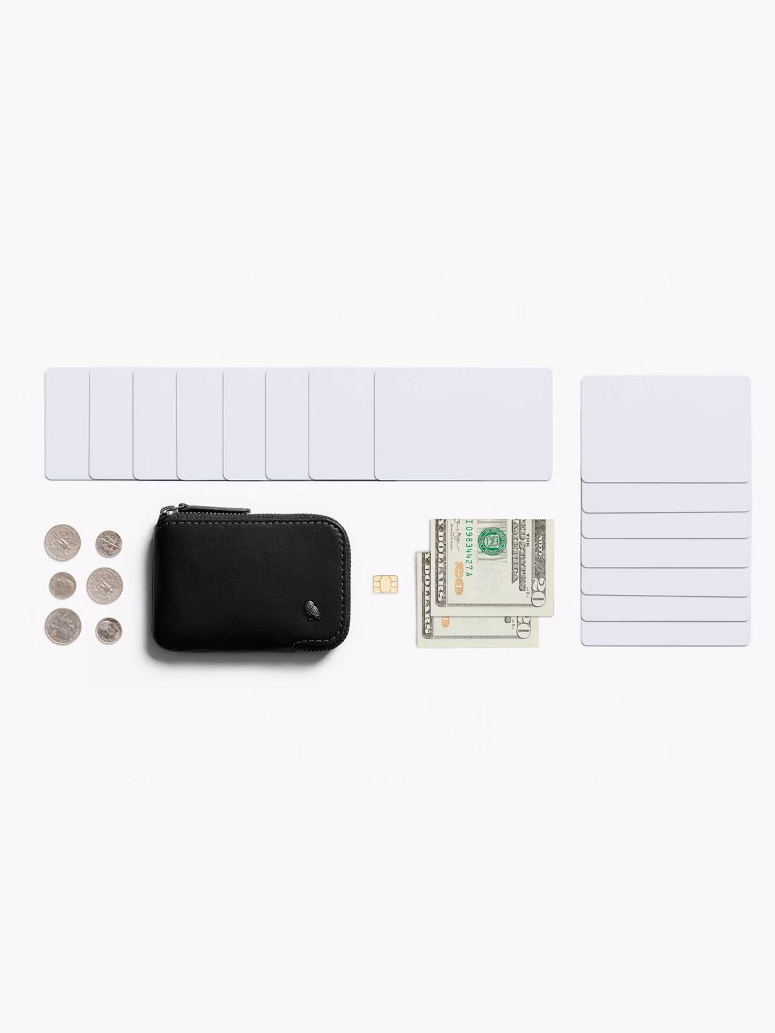 The Bellroy Card Pocket Wallet is displayed on a white background, surrounded by coins, blank card inserts, a SIM card, folded U.S. bills, and two stacks of blank cards.