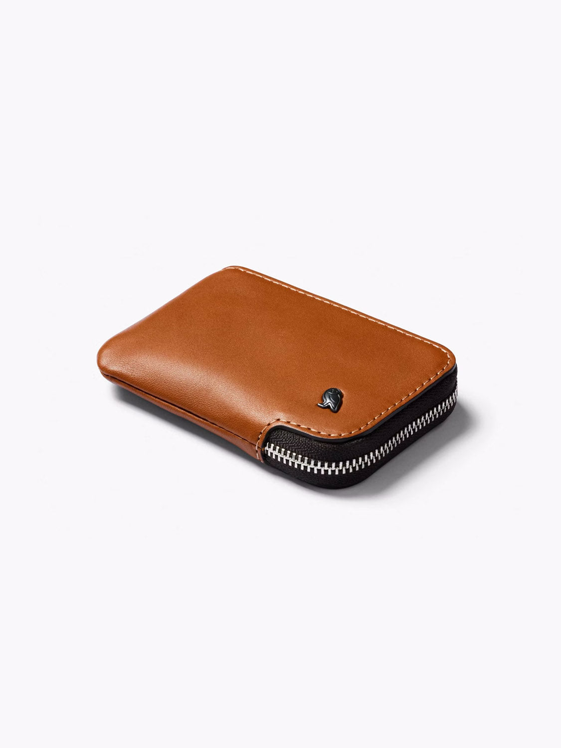 The Bellroy Card Pocket Wallet is a slim, brown leather wallet with white stitching, a small metallic logo, and a zippered closure, photographed on a plain light background.