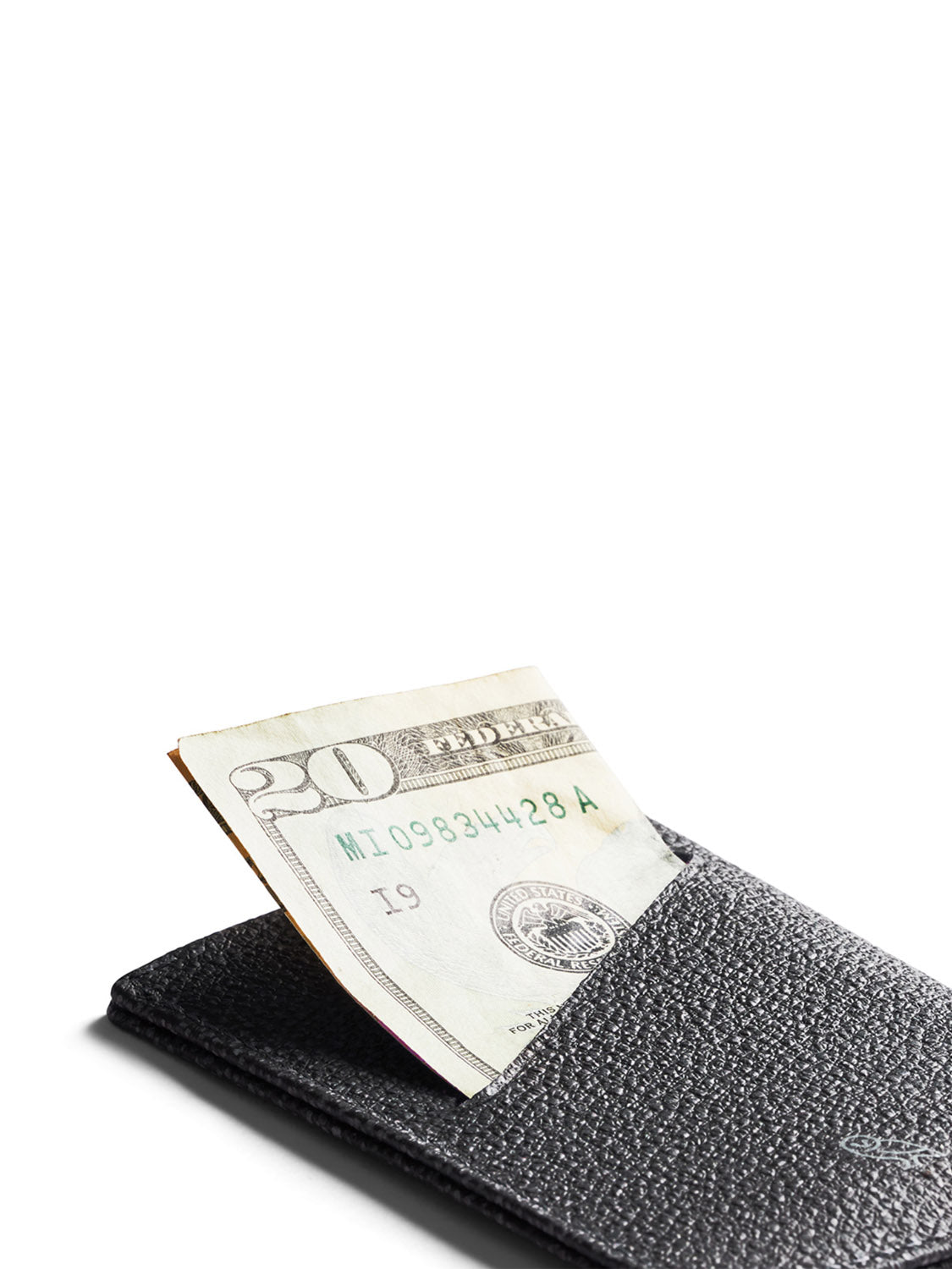 A close-up of the Bellroy Card Sleeve Wallet in black, featuring a folded twenty-dollar bill partially visible, set against a white background.