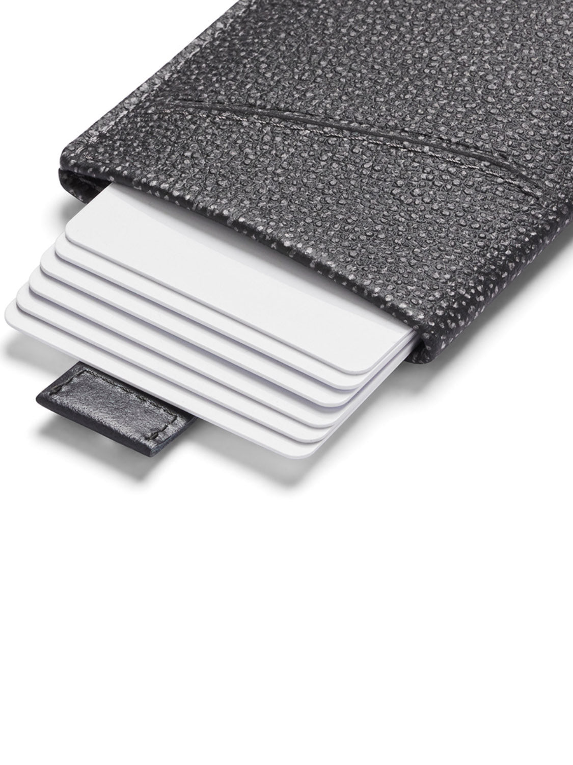 A close-up of the Bellroy Card Sleeve Wallet in black textured leather, displaying several white cards partially pulled out in a staggered arrangement to highlight this sleek minimalist accessory.