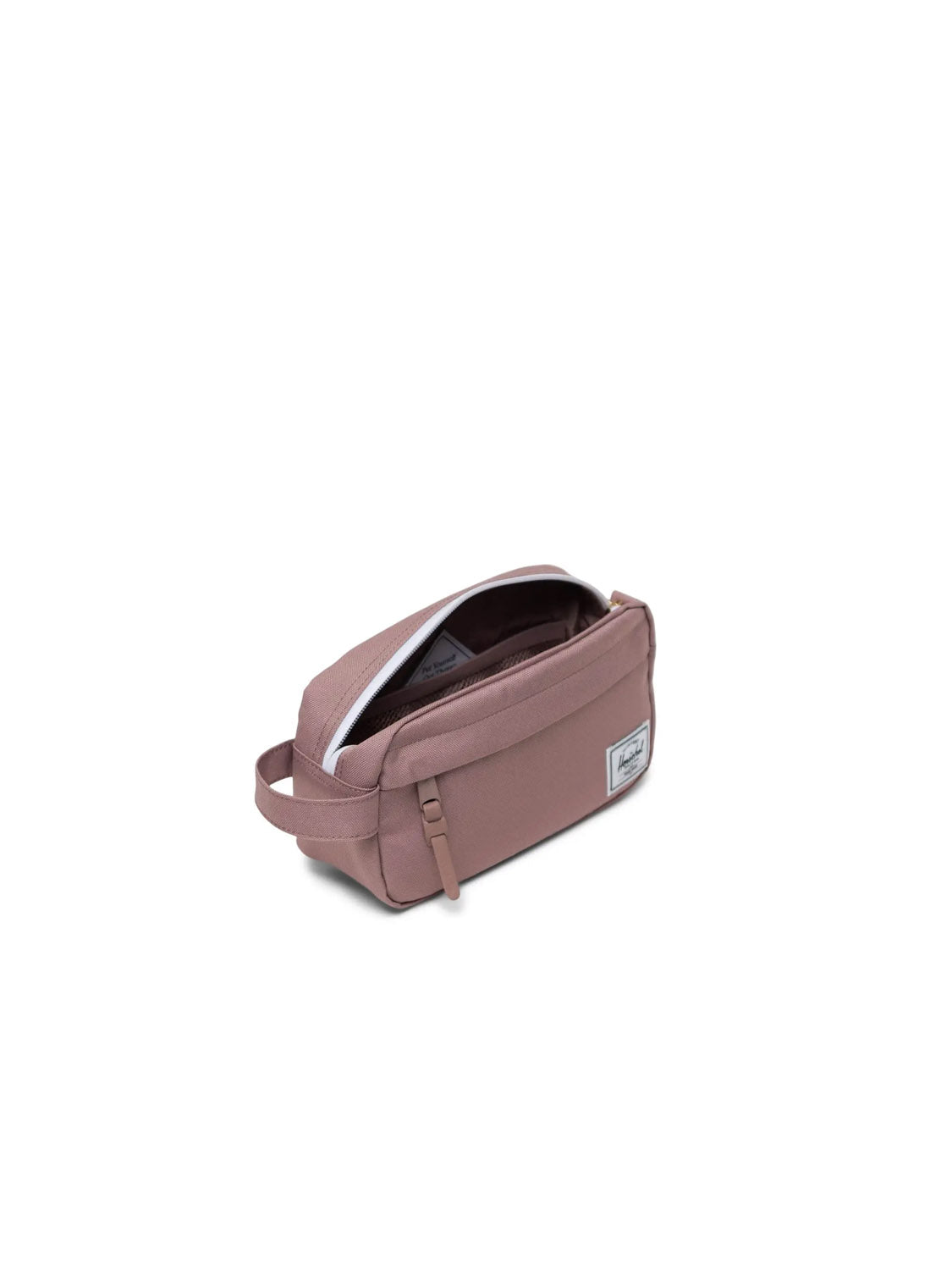 The Herschel Chapter Small Travel Kit is a mauve rectangular toiletry bag made from recycled fabric, with a side handle, partially open zipper showing a white-lined interior, and a small white logo patch on the front.