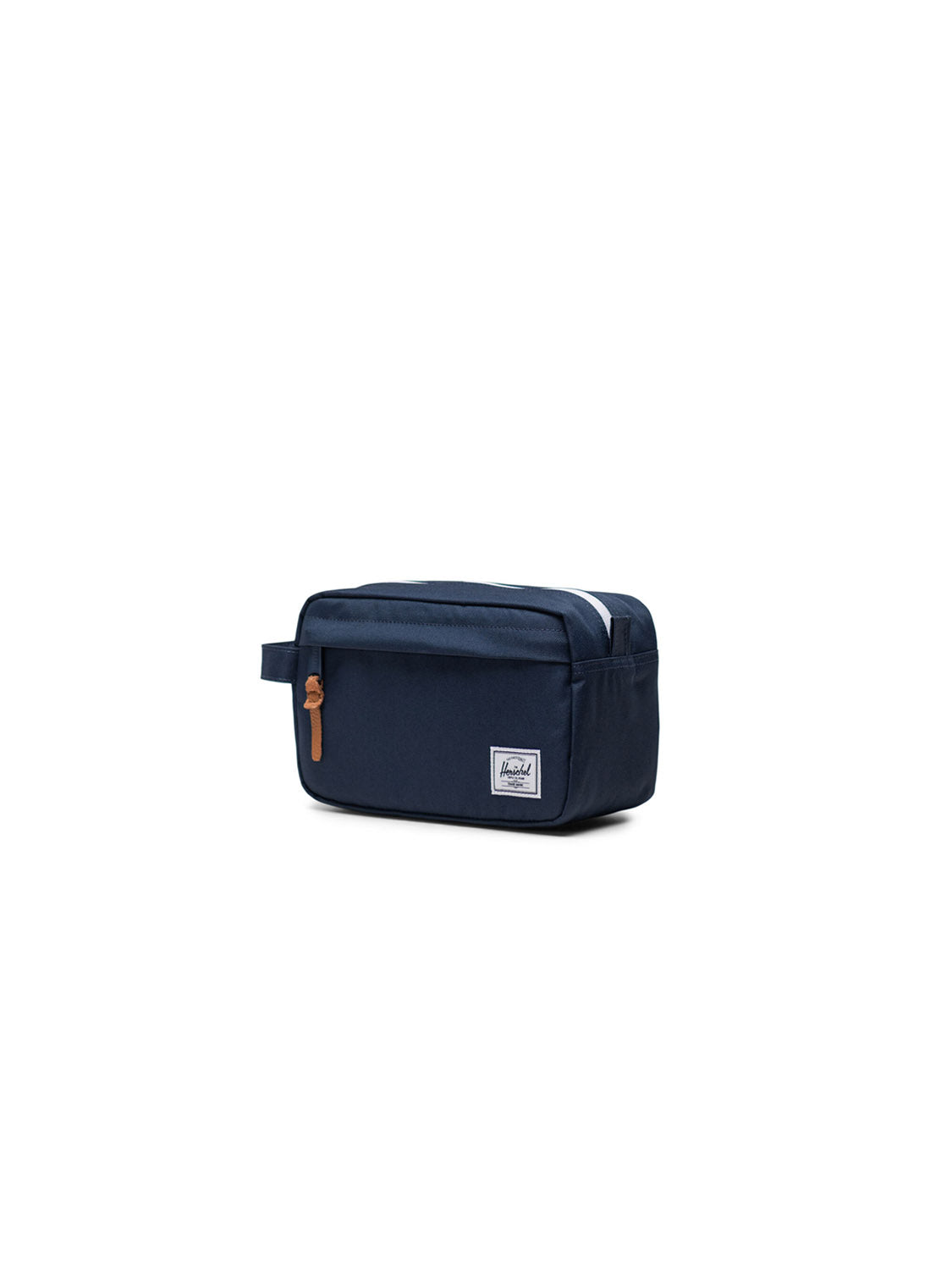 The Herschel Chapter Small Travel Kit is a navy blue rectangular, eco-friendly toiletry bag featuring a side handle, tan zipper pull, and a white patch label on the front, shown against a white background.