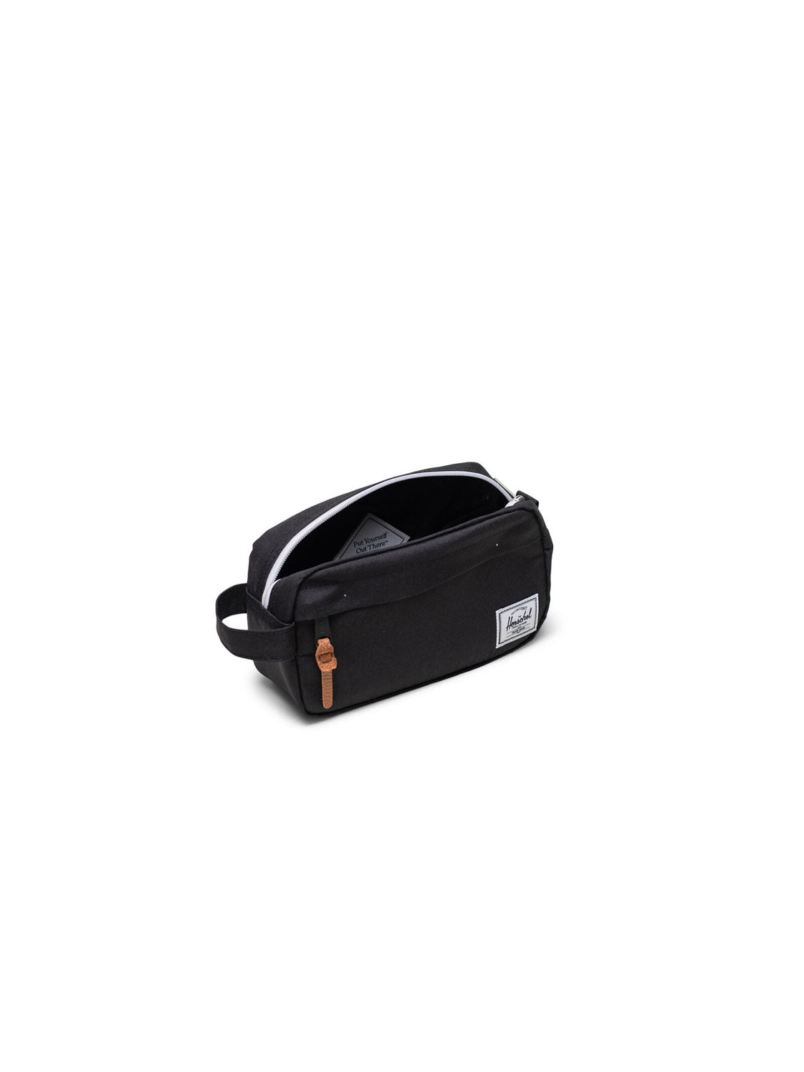The Herschel Chapter Small Travel Kit is a black rectangular bag with a white zipper, brown pull, side handle, and front white label—a stylish organizer displayed on a plain white background.