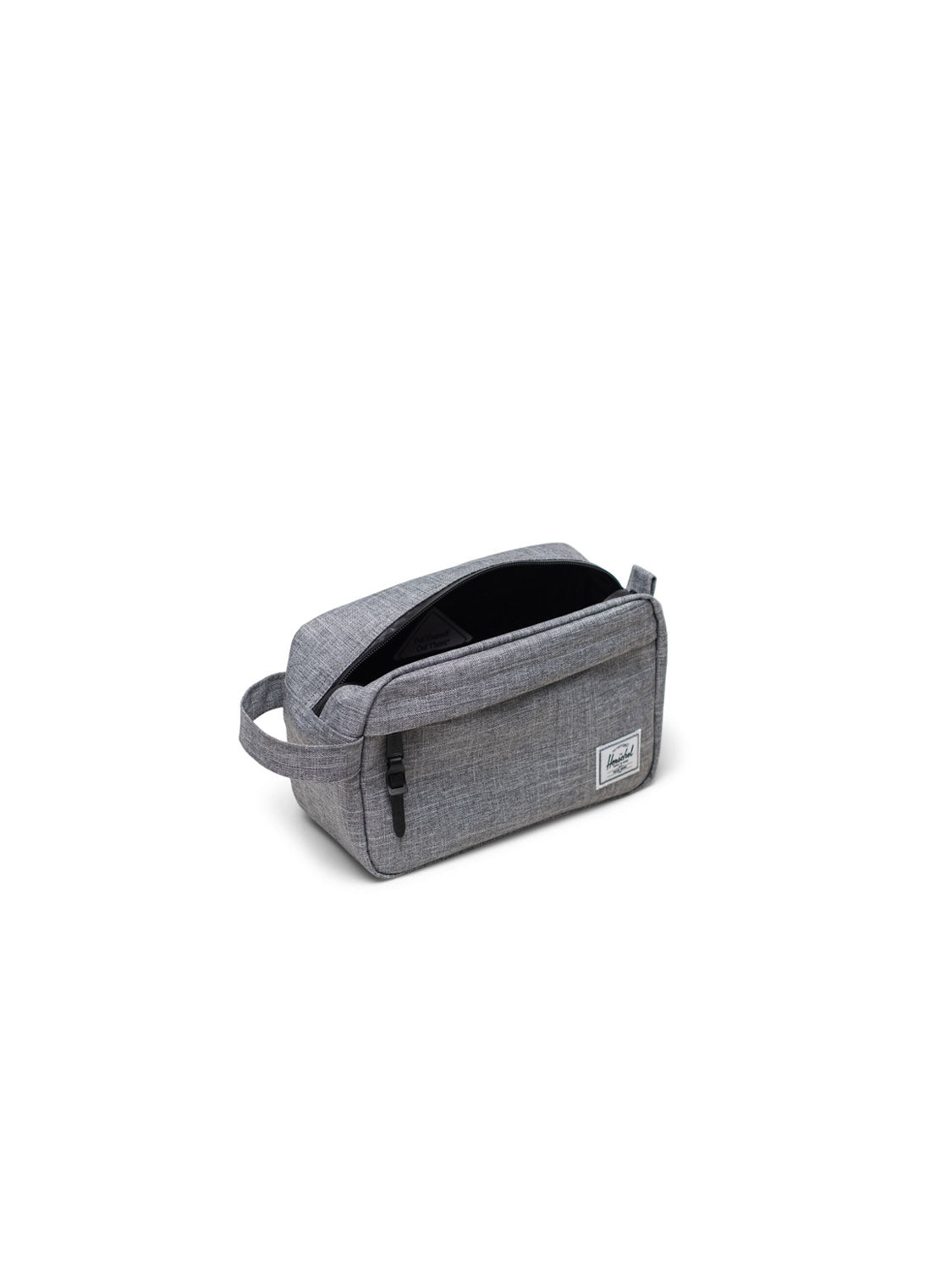 The Herschel Chapter Small Travel Kit is a grey, eco-friendly toiletry bag with a side handle and front zipper pocket, shown partly unzipped to reveal its black interior against a plain white background.
