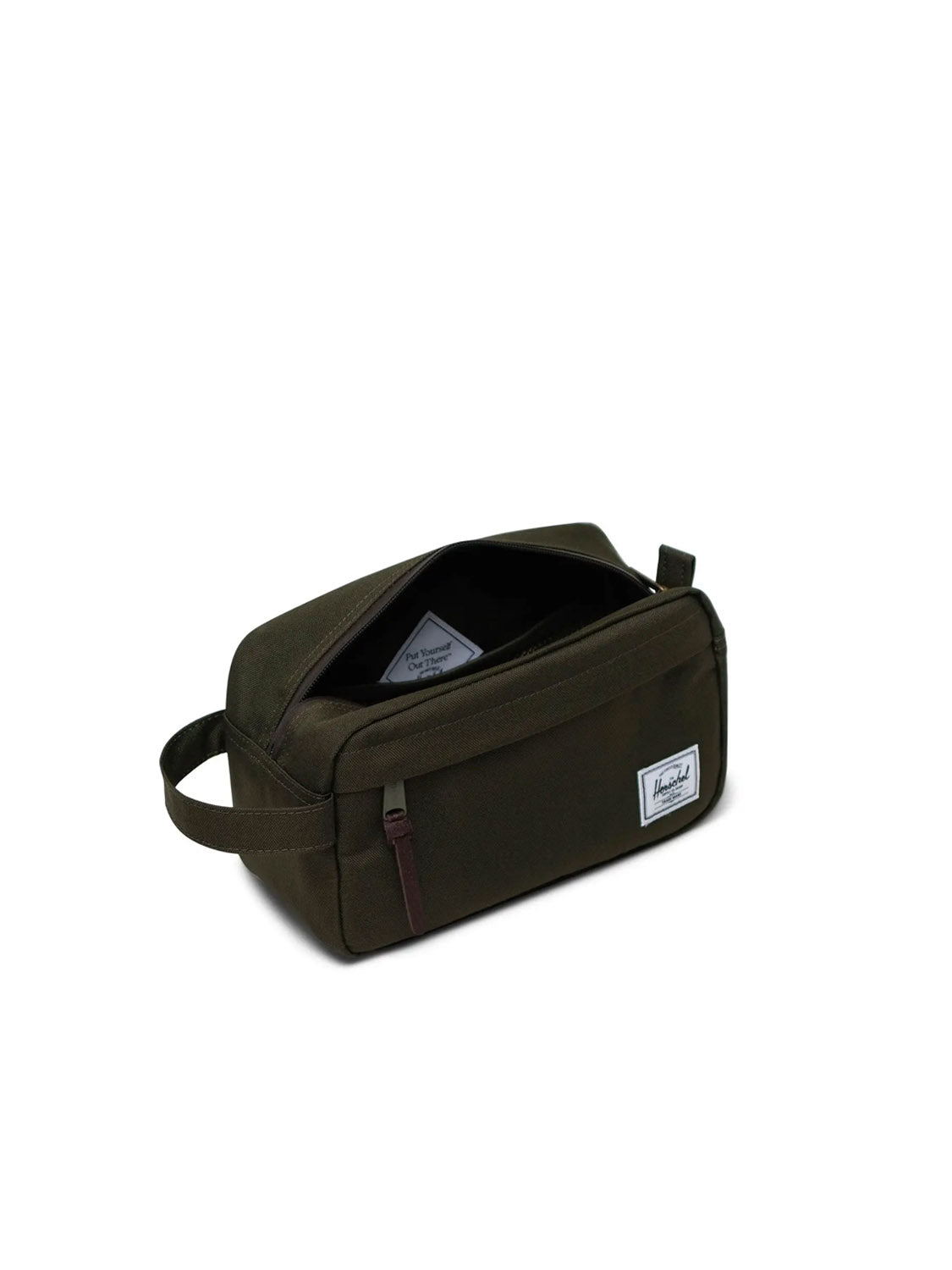 A dark green rectangular Herschel Chapter Travel Kit with a side handle, waterproof zipper, and a white Herschel label on the front. The open main compartment reveals an interior organizer and an inner label.