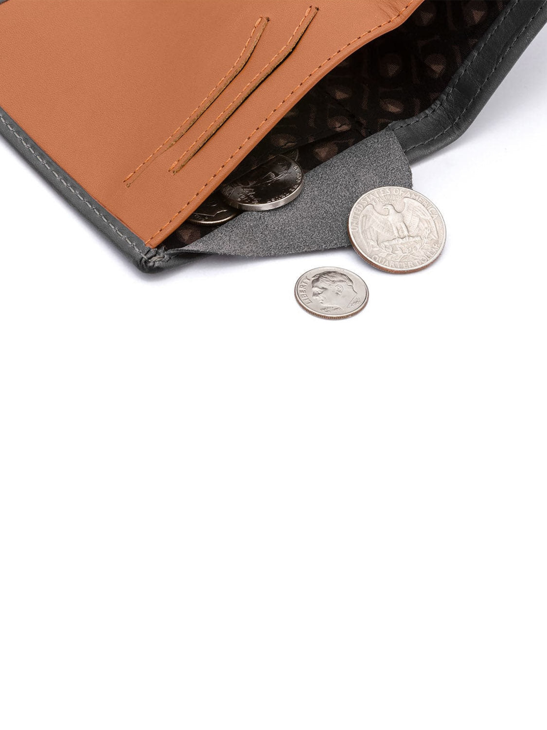 A Bellroy Note Sleeve Wallet in brown and gray sits open with coins inside, while a quarter and a dime lie next to it on a white surface.