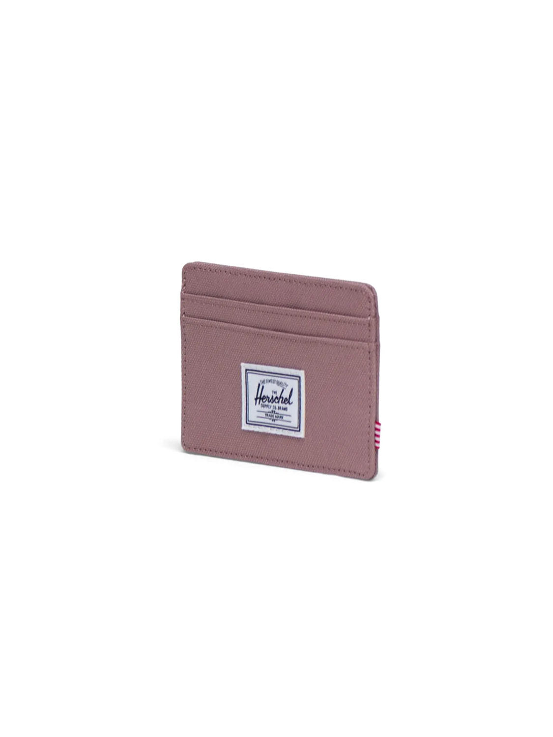 The Herschel Charlie Cardholder Wallet is a compact mauve cardholder with multiple slots and a white rectangular Herschel label on the front, shown on a plain white background.