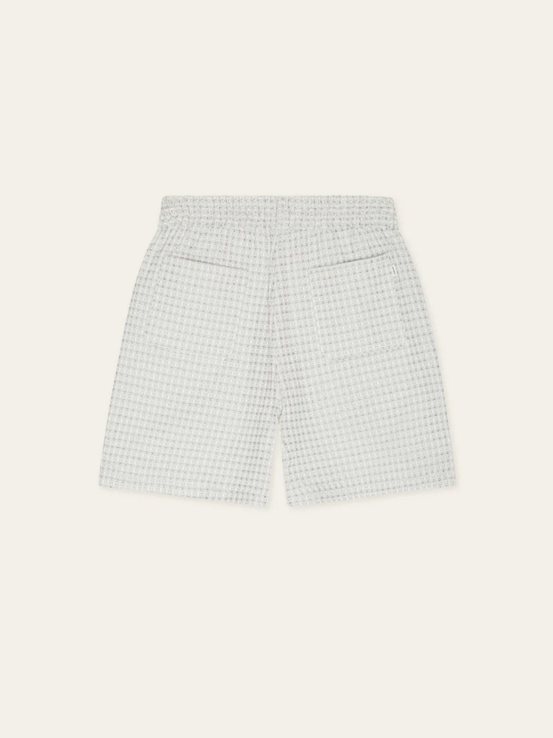Les Deux Check Seersucker Shorts in light gray and white, featuring an elastic waistband and two back pockets, are displayed flat on a light beige background.