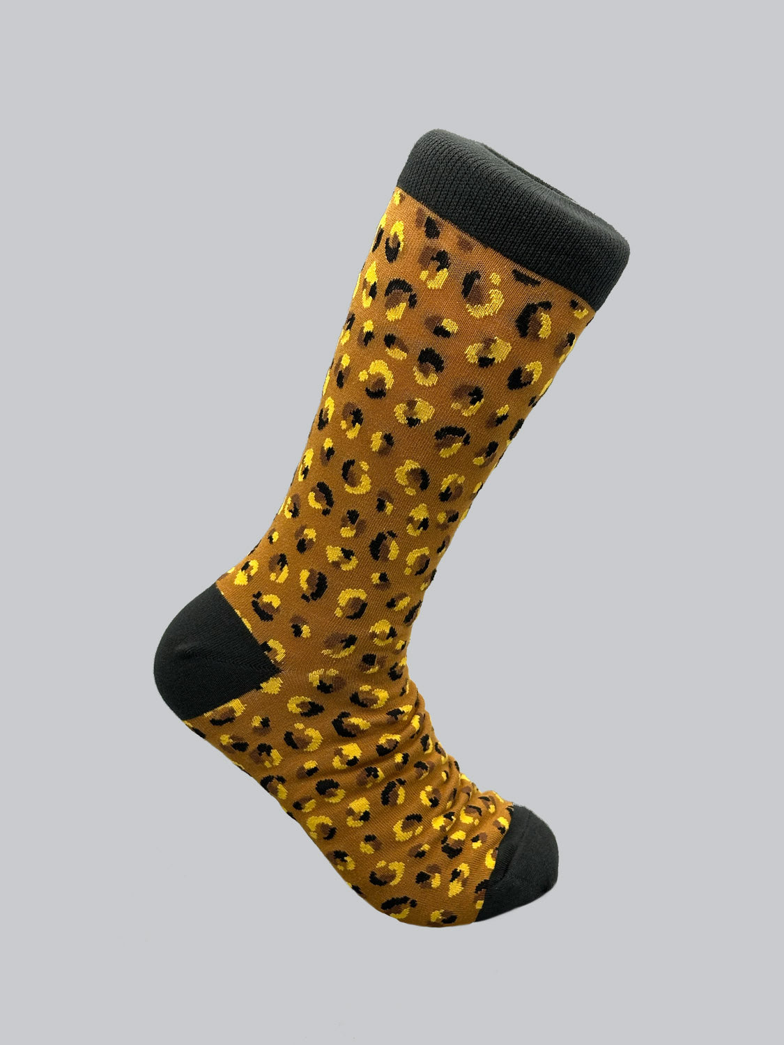ID Menswears Cheetah Graphic Sock is a single mens sock made of combed cotton, featuring a cheetah print on light gray fabric with black toes, heel, and cuff for added style.