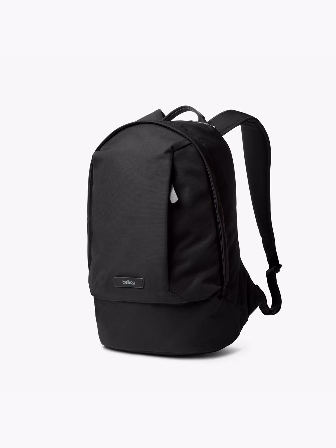 The Bellroy Classic Compact Backpack - 16L is a small black backpack with a minimalist design, featuring a front logo tag, top handle, and adjustable shoulder straps, shown against a plain white background.