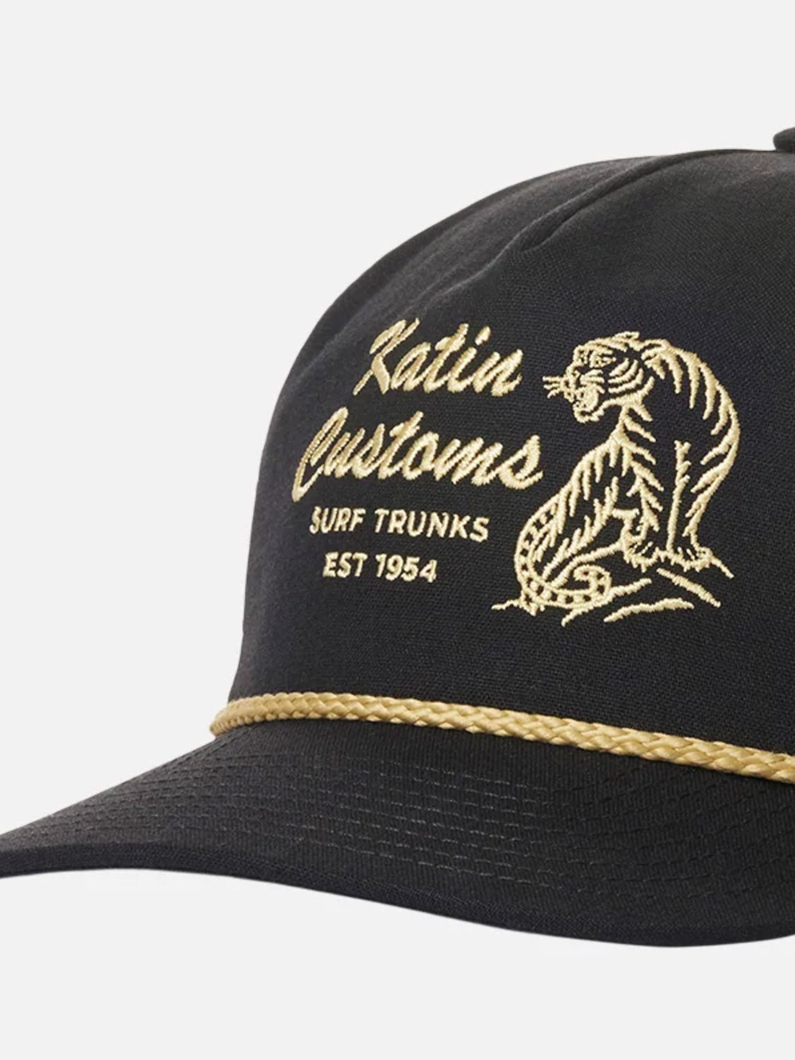 The Katin Claw Hat is a black baseball cap with gold tiger embroidery, "Katin Customs Surf Trunks Est 1954" text, a gold braided rope above the brim, and an adjustable snapback closure.