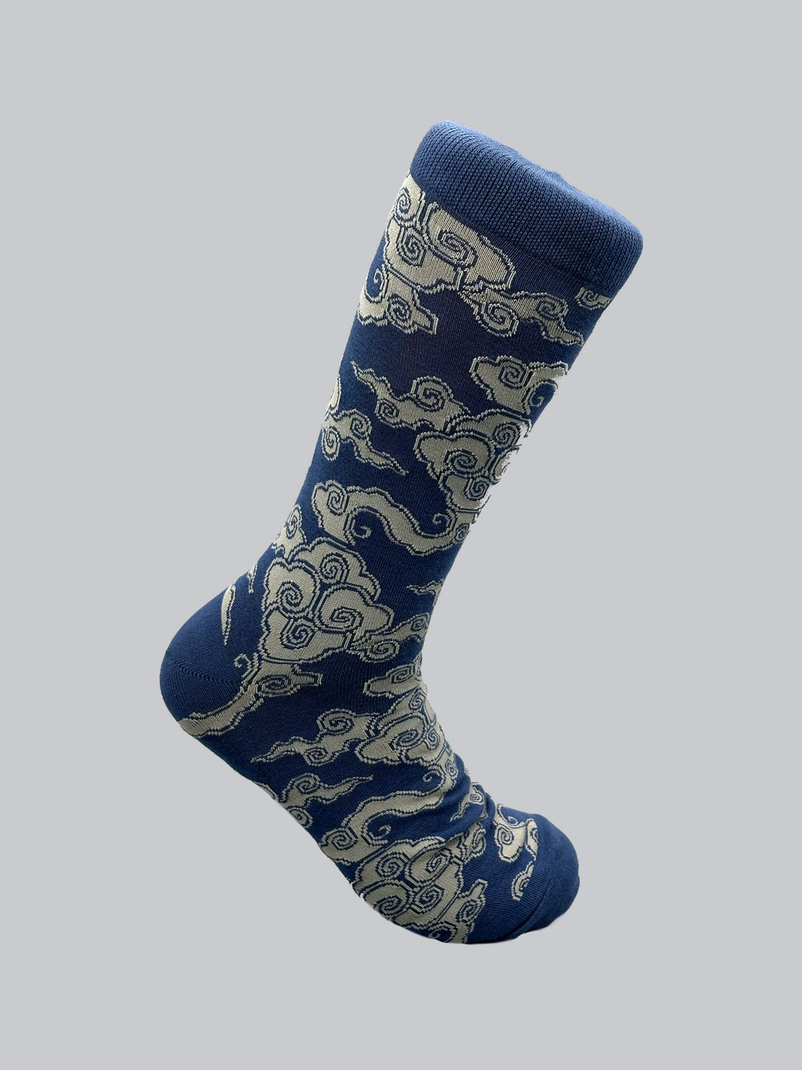 The plain gray background showcases ID Menswears Cloud Graphic Socks, featuring a swirling cloud pattern in light beige on breathable blue combed cotton.