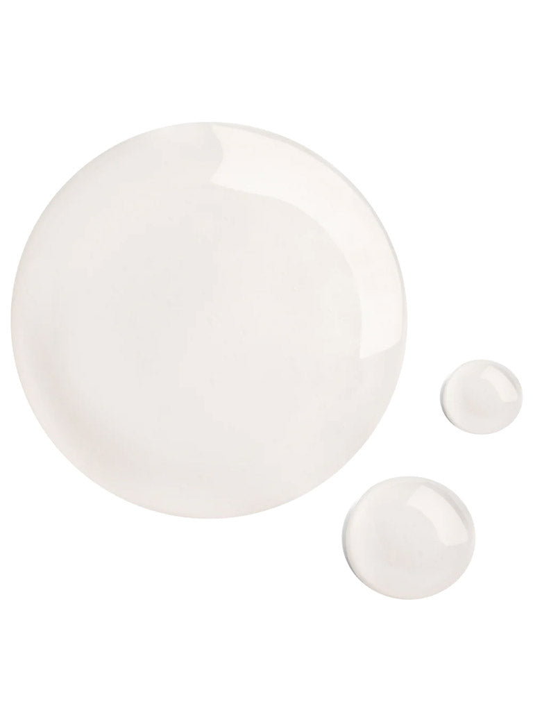 Three clear, glossy drops of Baxter Daily Face Wash—a sulfate-free cleanser—are displayed on a white background with one large and two small drops reflecting light, ideal for sensitive skin and daily use.