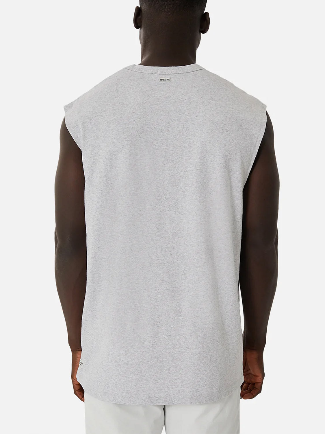A person faces away from the camera, wearing the Industrie Del Sur Sleeveless T-Shirt in breathable light gray and light-colored shorts, set against a plain white background.