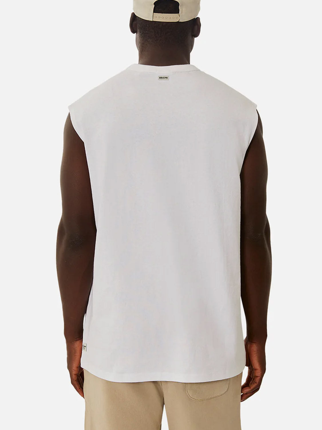 A person is shown from the back against a white background, wearing the Industrie Del Sur Sleeveless T-Shirt in white, paired with beige shorts and a beige cap.