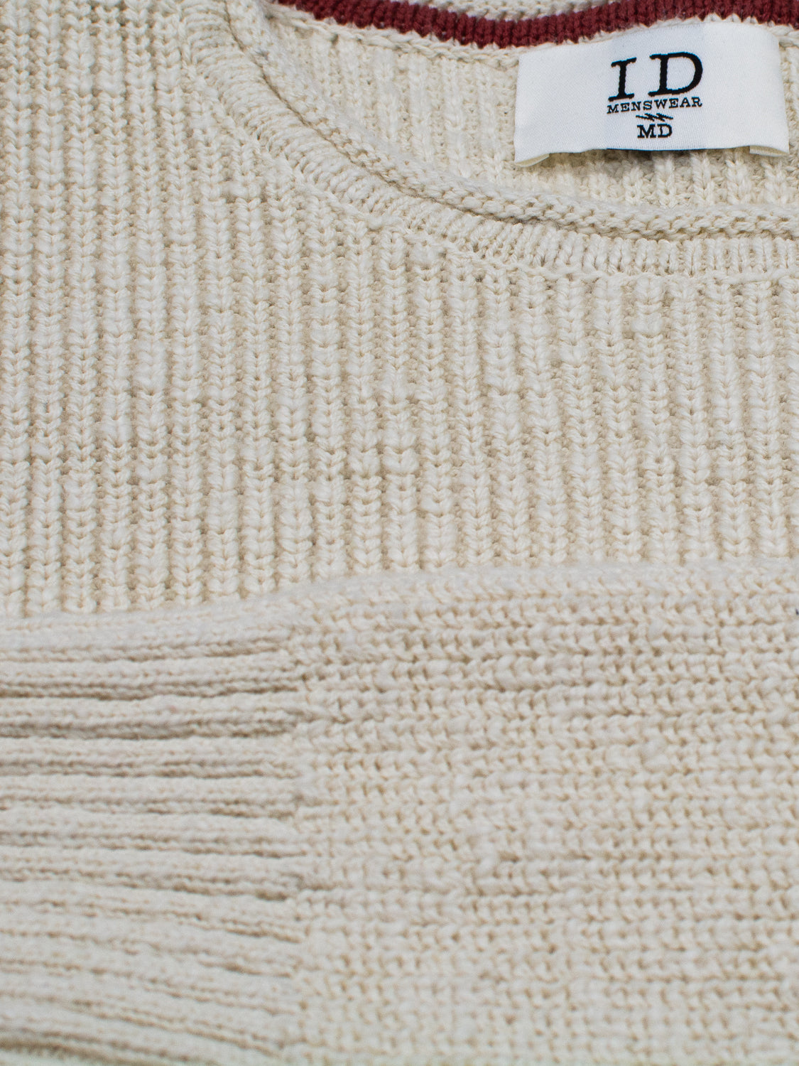 Close-up of a beige Dublin Slub Cotton Rolled Neck Sweater with visible ID Menswear label at the neckline. The ribbed texture and stitching details are highlighted around the collar and shoulders—ideal for cooler weather.