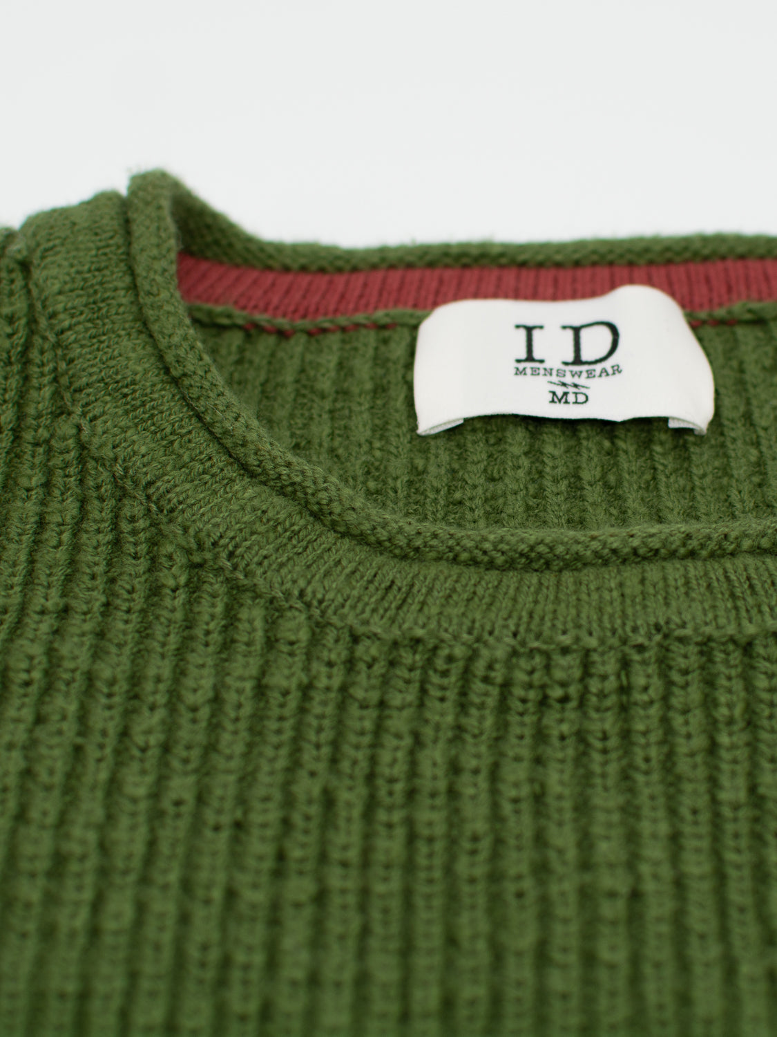 Close-up of a Dublin Slub Cotton Rolled Neck Sweater by ID Menswear. Inside, a white label stitched on red fabric reads ID Menswear MD. Its knit texture is ideal for cooler weather, and the craftsmanship is clearly visible.