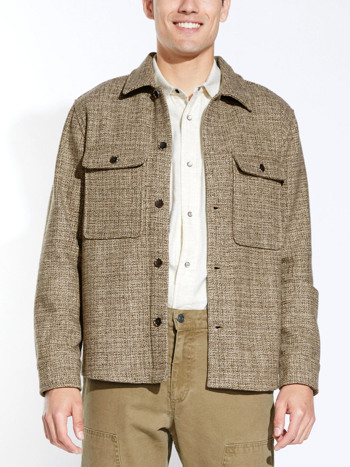 A man smiles in a Civil Society Durbin Relaxed Fit Shirt Jacket, featuring marled twill fabric and two chest pockets, paired with khaki pants. The background is plain white.