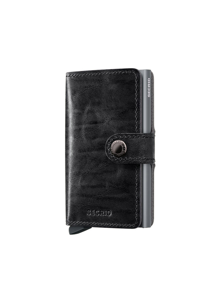 A black Secrid Miniwallet Dutch Martin with a snap-button closure, visible card slot, and compact minimalist design. This RFID wallet is shown against a white background.